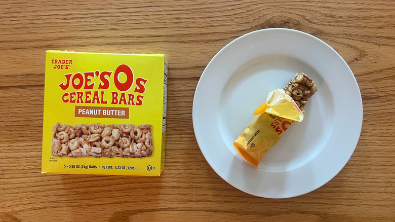 A box of Joe's O's Peanut Butter Cereal Bars with one partially unwrapped on a plate