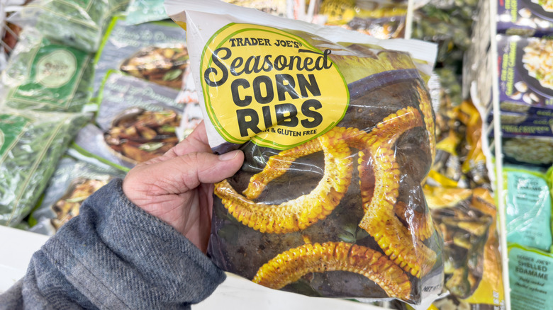 Hand holding a bag of frozen Trader Joe's Seasoned Corn Ribs