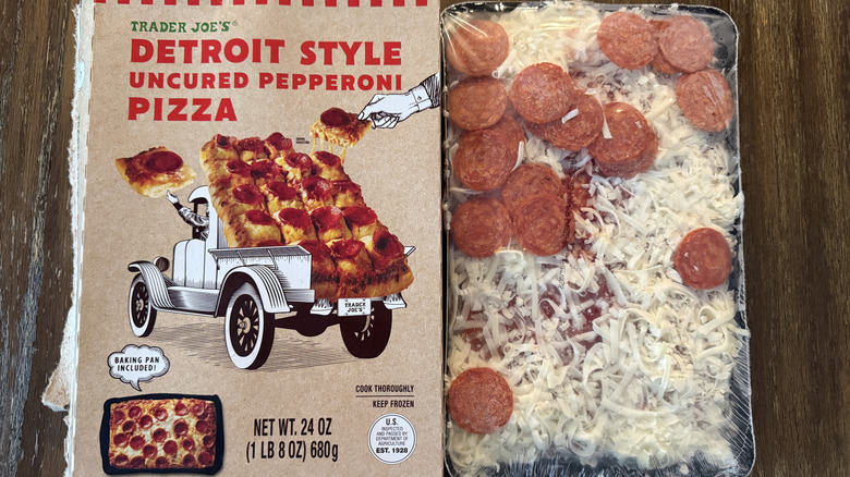 Trader Joe's Detroit Style Pepperoni Pizza wrapped in baking tray next to its box on wooden table
