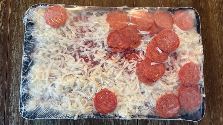 Trader Joe's Detroit-style pepperoni pizza wrapped in baking tray on wooden surface