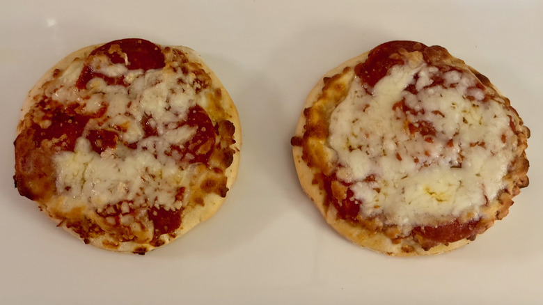 Two small red sauce pizzas on a white background.
