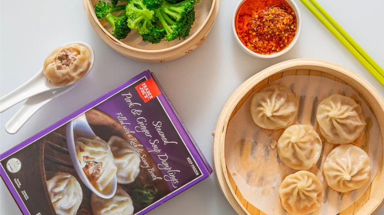 Trader Joe's Pork and Ginger Soup Dumplings with various food around the package.