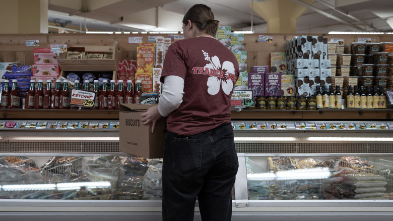 Employee restocking the Trader Joe's frozen section