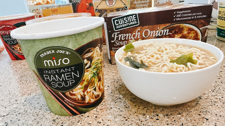 Trader Joe's Miso Ramen next to some in a white bowl with other TJ's soups in background