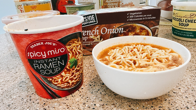 Trader Joe's Spicy Miso Ramen next to some in a white bowl with other TJ's soups in background