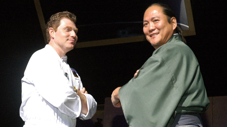 Bobby Flay and Masaharu Morimoto on stage facing each other