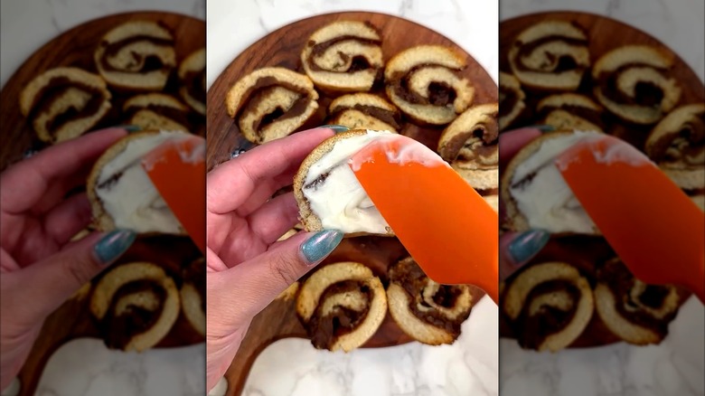 Spreading frosting on King's Hawaiian cinnamon rolls