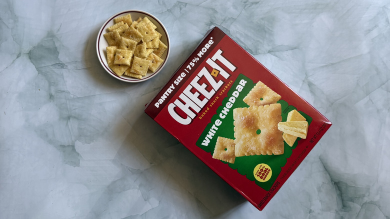 Box of Cheez-It White Cheddar Snack Crackers next to bowl of the Cheez-Its