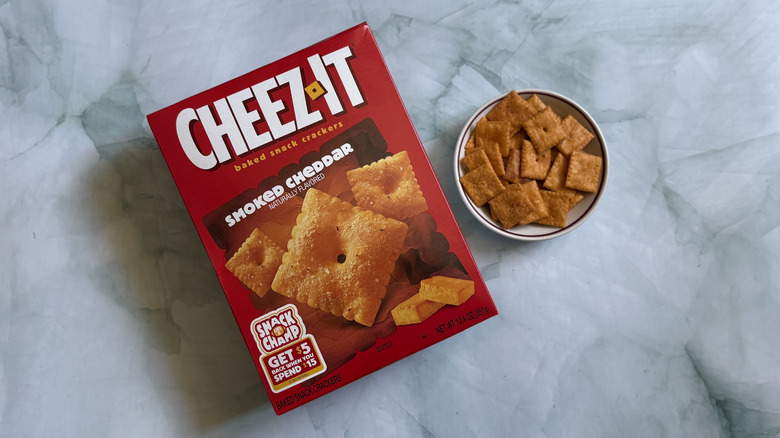Box of Cheez-It Smoked Cheddar Snack Crackers next to bowl of the Cheez-Its