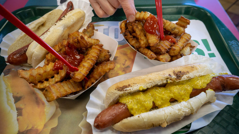 Tray with Nathan's famous hot dog with deli mustard alongside crinkle cut fries with ketchup
