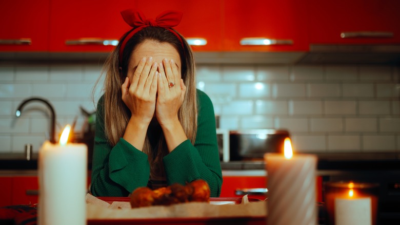 Girl with hands on her face with Christmas decor in kitchen background