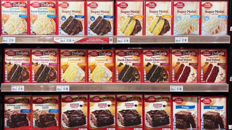 Different flavors of boxed cake mix sitting on the shelf at the grocery store.
