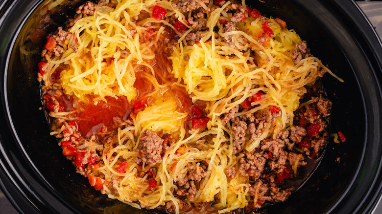 ground beef in a crockpot with tomatoes and shredded squash