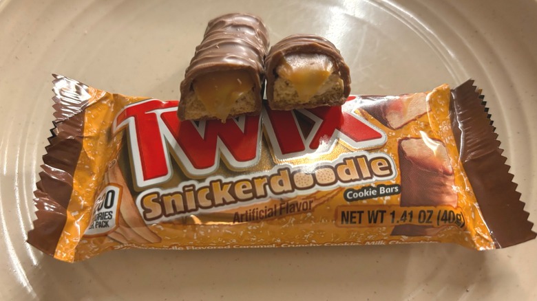 Broken Twix Snickerdoodle bar on top of a wrapped candy bar