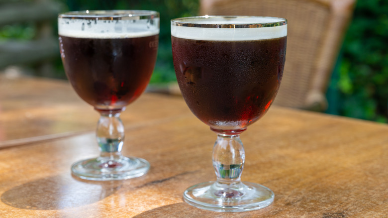 Two glasses of Belgian dubbel beer on a table