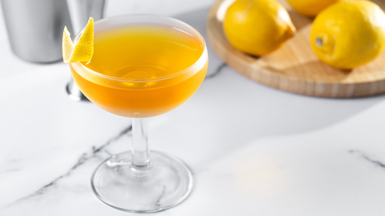 Paper plane cocktail on white marble background.
