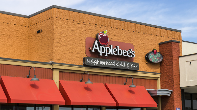 Applebee's restaurant exterior with orange facade, red awnings, and restaurant logo on bright day