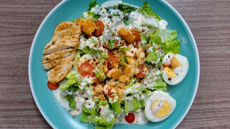 Bowl of salad with chicken, cherry tomatoes, and hard-boiled eggs