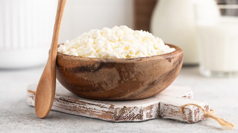 Wooden bowl of cottage cheese with wooden spoon
