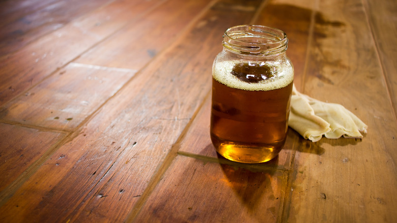 A Mason jar of used cooking oil on wooden table