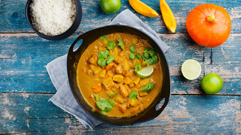 pumpkin curry in a bowl, next to a bowl of white rice