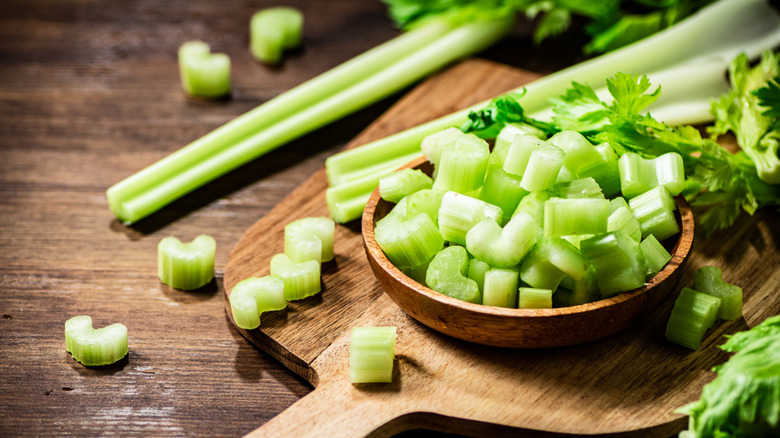 chopped celery on a cutting board and in a bowl