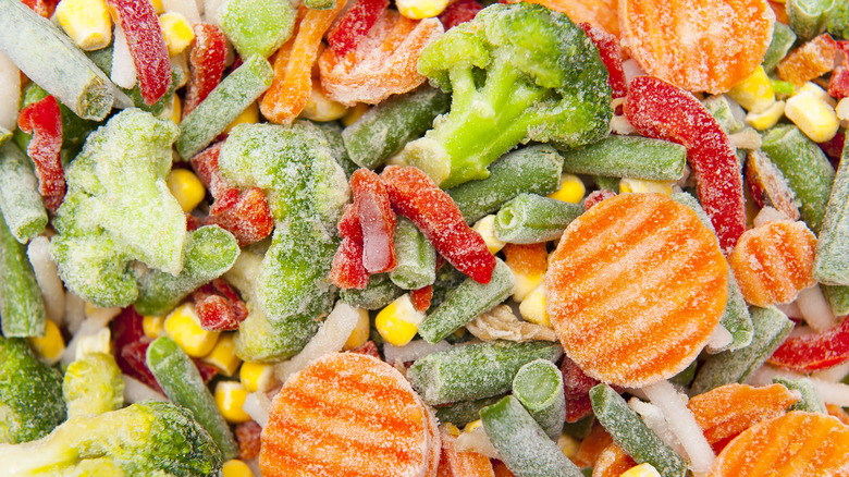 Close up of frozen vegetable mix including sliced carrots, peas, corn, and broccoli
