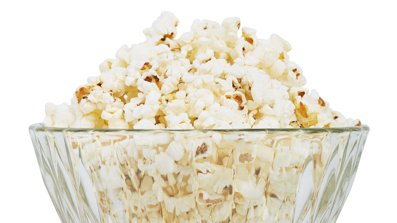 Popcorn in a glass bowl with a white background