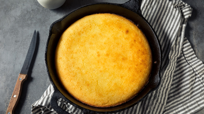 Cast iron skillet with golden baked cornbread inside.