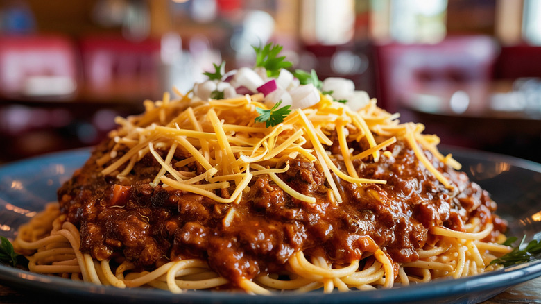 Extreme close-up of Cincinnati chili, spiced meat sauce served over spaghetti, topped with cheese.