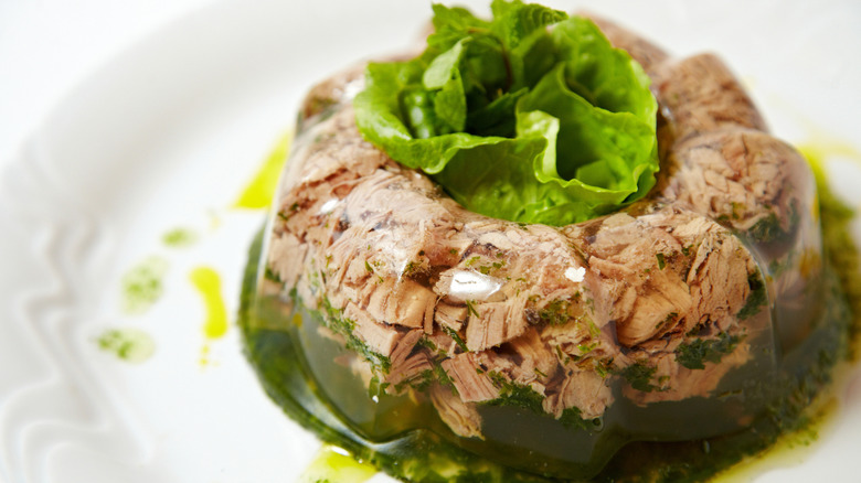 Jellied pork and beef on a plate, close up on white