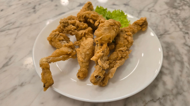 Fried frog legs on a white plate