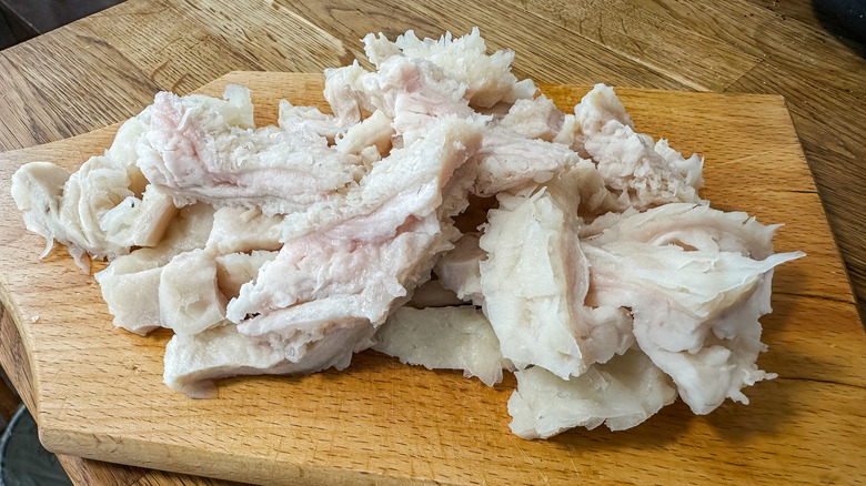 A pile of freshly cut raw trip on wooden cutting board