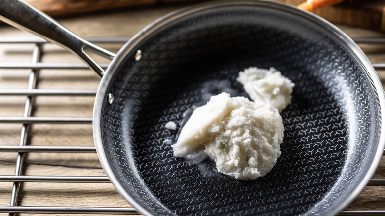 Lard melting in a black frying pan