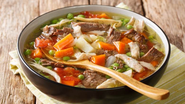Booyah stew with vegetables close-up in a plate on the table.