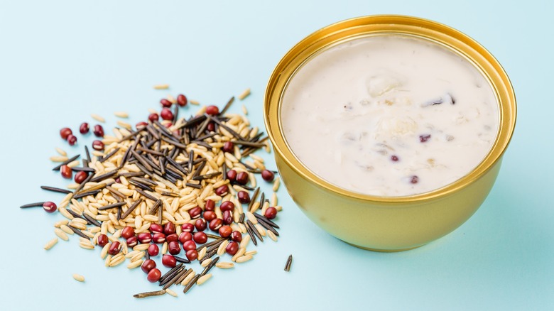 Ingredients for wild rice porridge next to a bowl filled with milky porridge