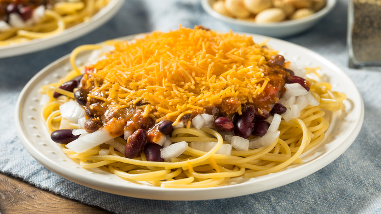 Cincinnati chili spaghetti with cheese and onion in a bowl