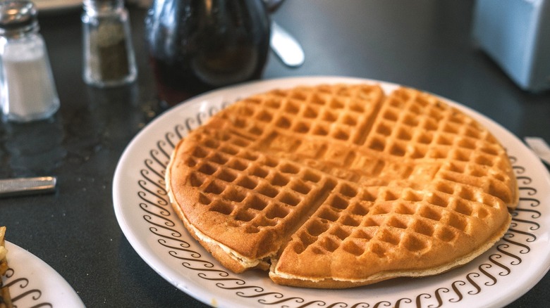 A Waffle House waffle with syrup and silverware