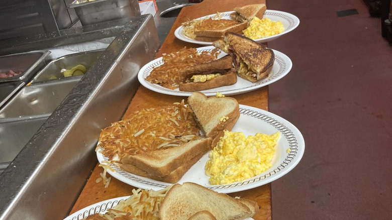 A series of order plates on a table in a Waffle House kitchen.