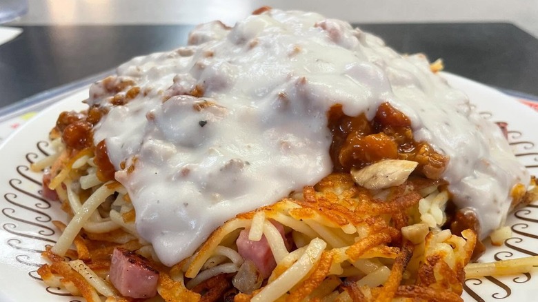 A plate of Waffle House hash browns covered in sausage gravy.