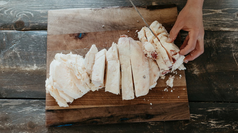 Cutting up beef tallow on a wood cutting board