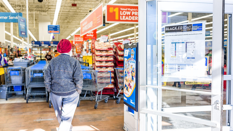 A person walking through the entrance of a Walmart location as Black Friday and the holiday season approaches