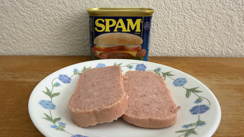 two slices of Spam on a plate with the can in the background