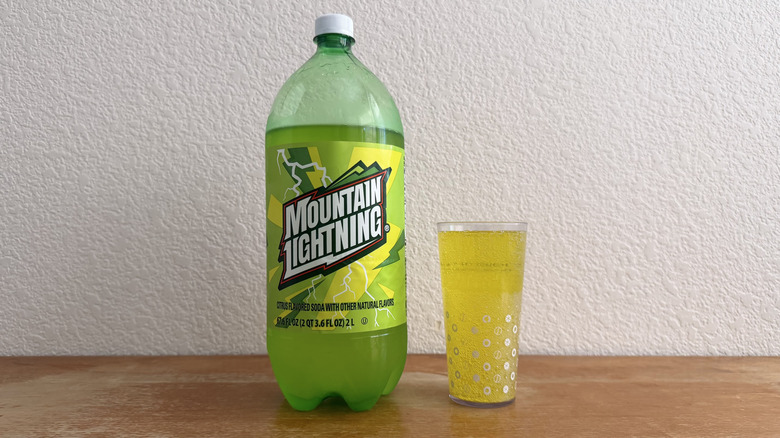two-liter bottle of Mountain Lightning beside a filled cup