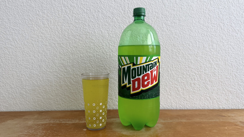 two-liter bottle of Mountain Dew beside a filled cup
