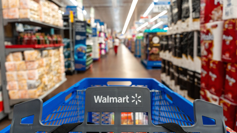 A Walmart shopping cart, close-up, in an aisle