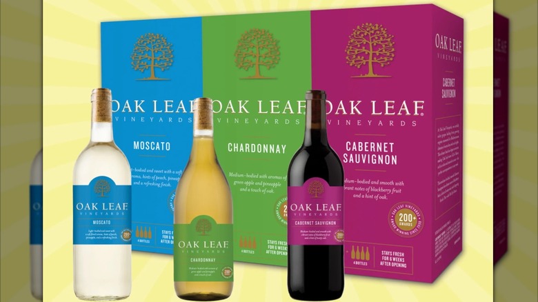 3 Bottle of Oak Leaf wine in front of boxes of wine, isolated on pale yellow background
