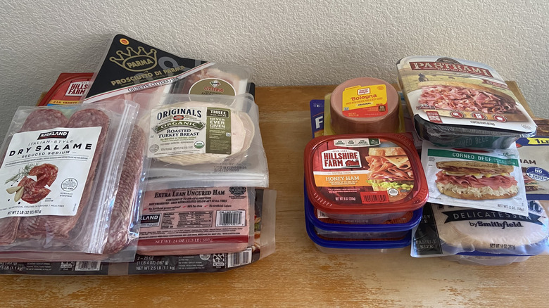 piles of each store's deli meats on a table
