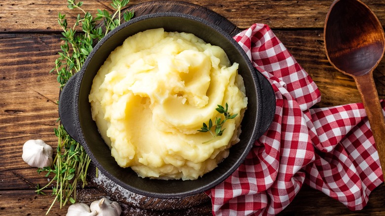 Mashed potatoes in black bowl on wood table