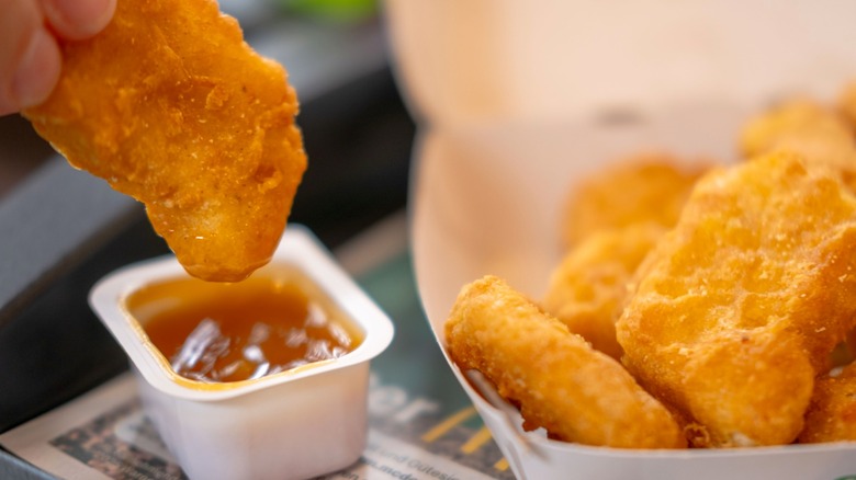 Person dipping McNuggets into sauce